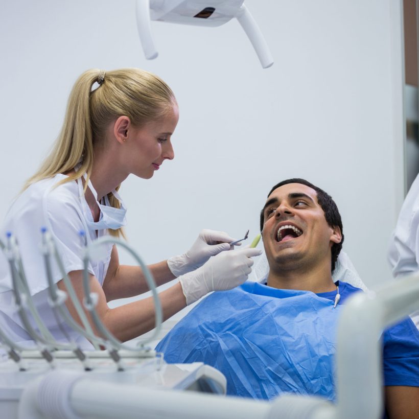 Dentist examining a patient with tools at clinic