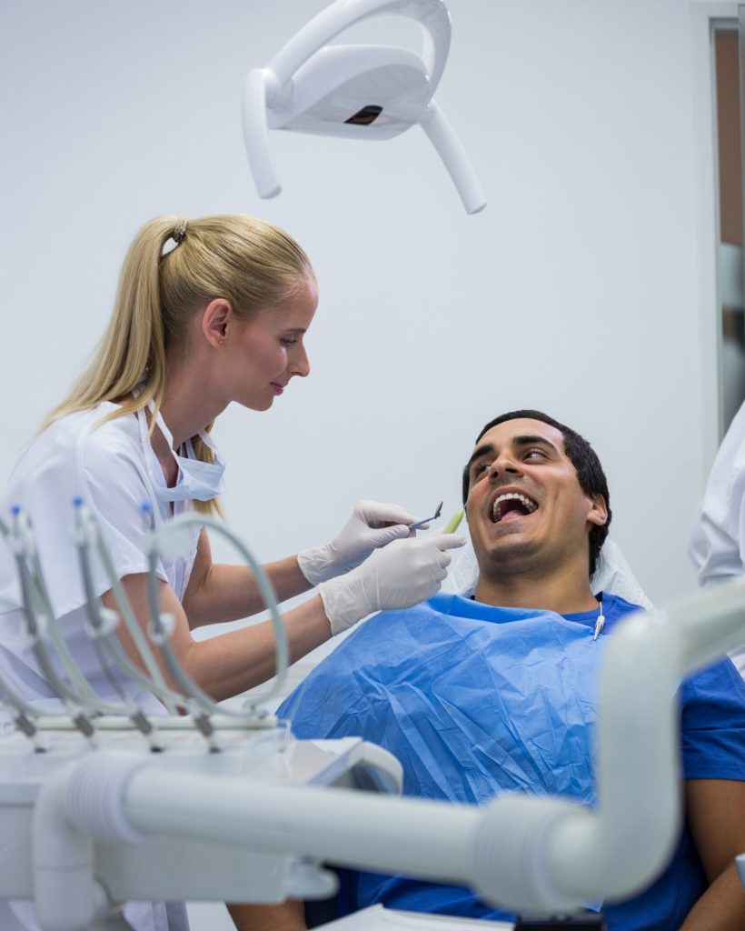 Dentist examining a patient with tools at clinic